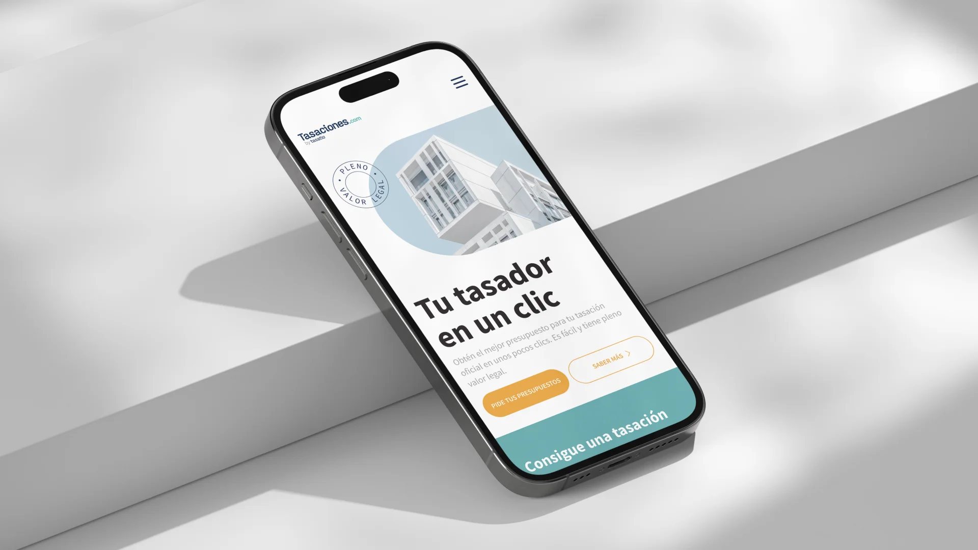 Tasaciones.com home screen on a mobile device, with the slogan Tu tasador en un clic and buttons to register or start a valuation.